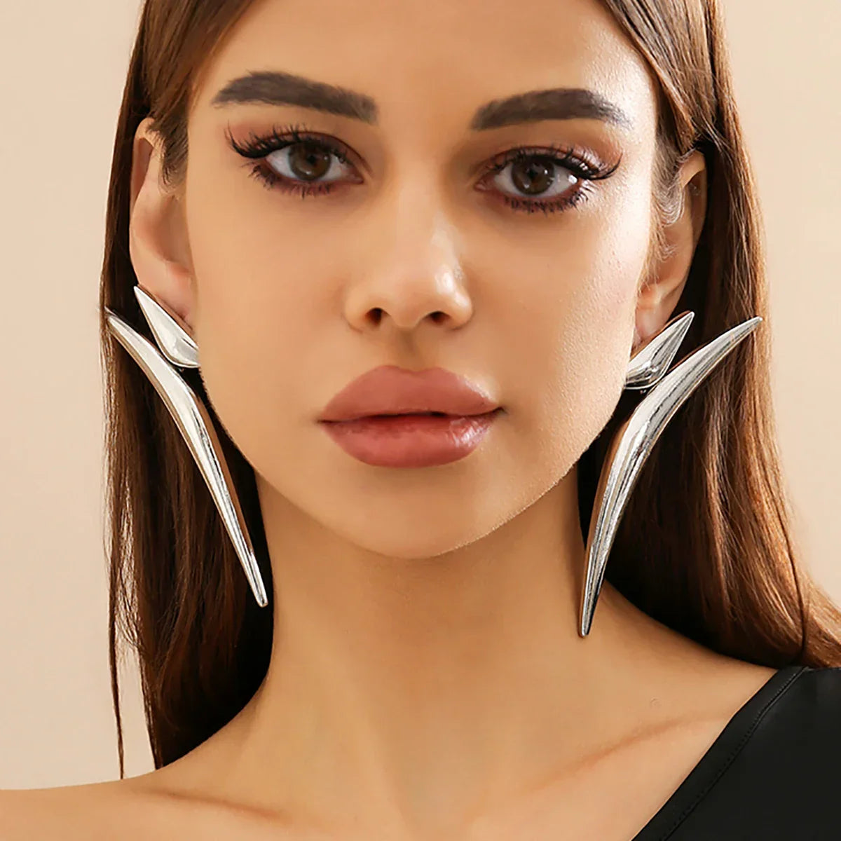 Model wearing silver-tone Sleek Aeonian Ear Wings. Geometric statement earrings with a futuristic and elegant appeal.