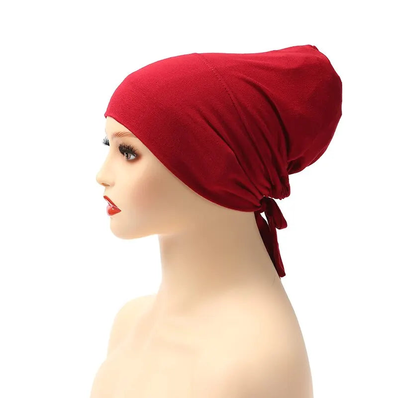 Red adjustable headwrap displayed on a mannequin, highlighting its soft fabric and secure tie-back closure.