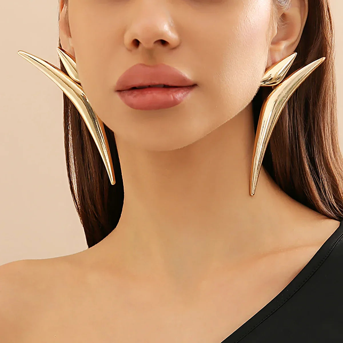 Close-up of model wearing Sleek Aeonian Ear Wings, highlighting their bold and modern design. Gold-tone geometric earrings for a chic look.