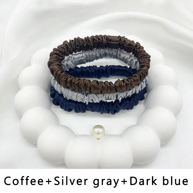Set of three mulberry silk elastic hair bands in coffee, silver gray, and dark blue. Gentle hold for frizz-free styling of natural hair.