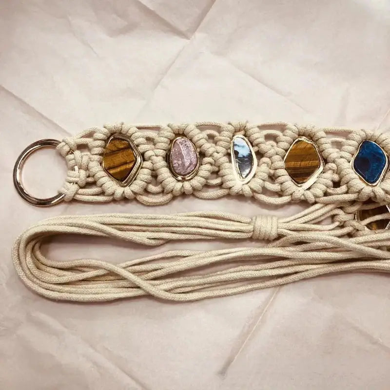 Bohemian-style woven tassel belt with hand-braided macramé and embedded gemstones. Designed with a sturdy metal ring for adjustable fastening.