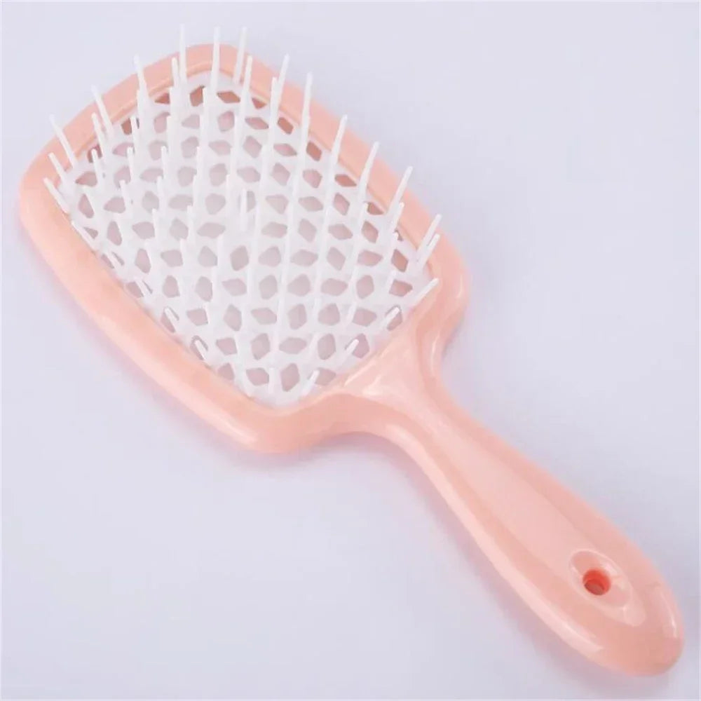 Black detangling brush with pink bristles, designed for curly hair. Helps reduce breakage and ensures smooth, effortless detangling.