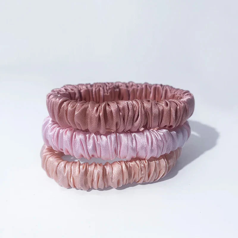 Set of three pink-toned mulberry silk elastic hair bands. Gentle, snag-free ponytail holders for smooth, frizz-free styling.