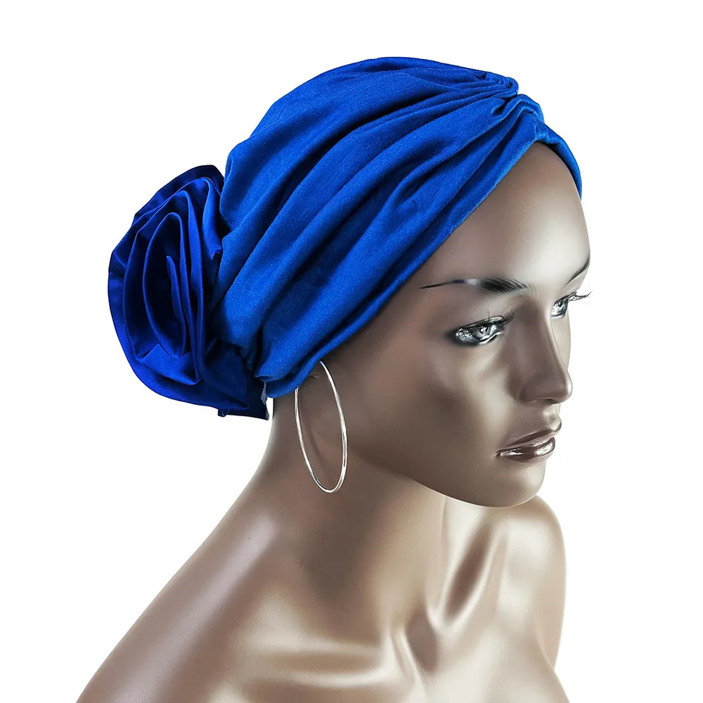 Royal blue floral stretch bandana head wrap displayed on a mannequin. Soft, stretchy fabric with a stylish fabric rose at the back.
