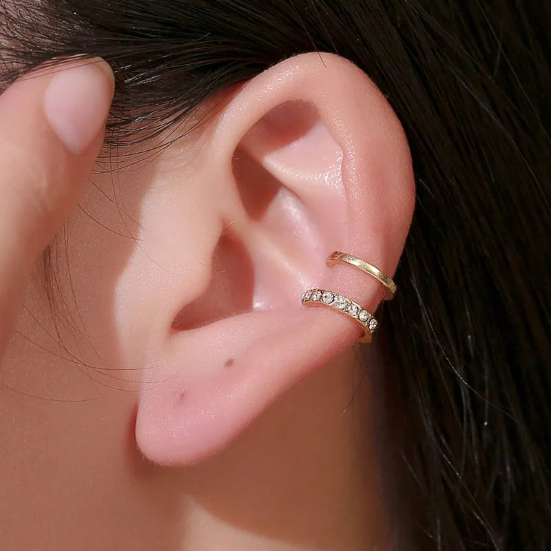 Gold-tone rhinestone double-band ear cuff worn by a model. Elegant and stylish modern vintage earrings for women.