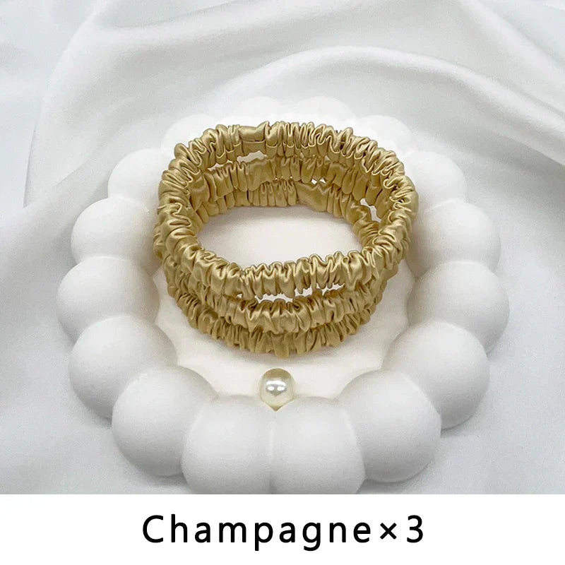 Three champagne-colored mulberry silk elastic hair bands. Smooth, frizz-free styling for natural and delicate hair.