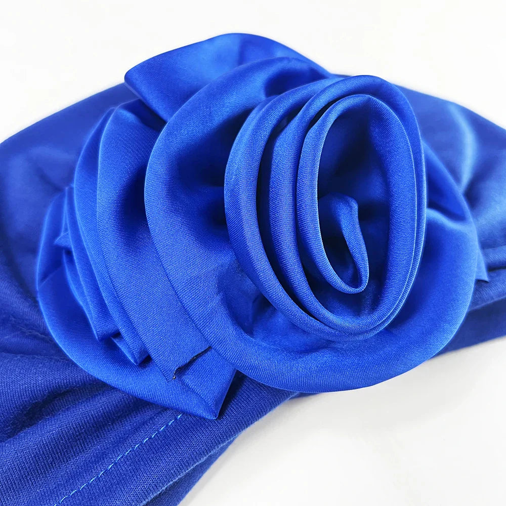 Detailed view of the floral fabric rose on the royal blue stretch bandana head wrap. Elegant design with smooth, high-quality fabric.