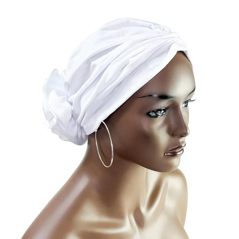 White floral stretch bandana head wrap displayed on a mannequin. Soft, stretchy fabric with a stylish fabric rose at the back.