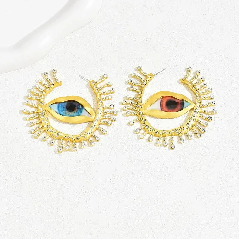 Visionary Gaze Earrings featuring an intricate eye design with gold-tone detailing and crystal embellishments. Unique fashion earrings for women.