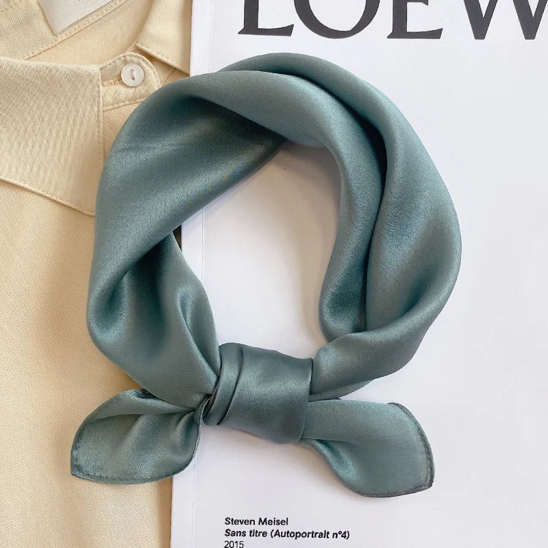 Silk Bandana Scarf - Ivory Elegant draped over a beige shirt and fashion magazine, showcasing its smooth 100% silk texture and timeless hue.