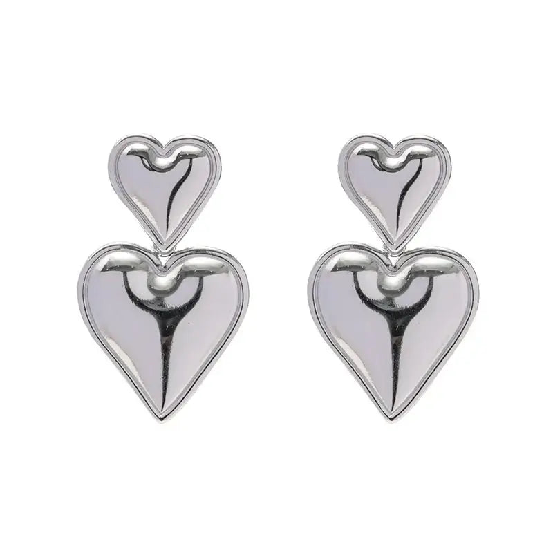 Silver double-heart earrings with a polished finish, featuring a bold and elegant design. A trendy statement accessory.