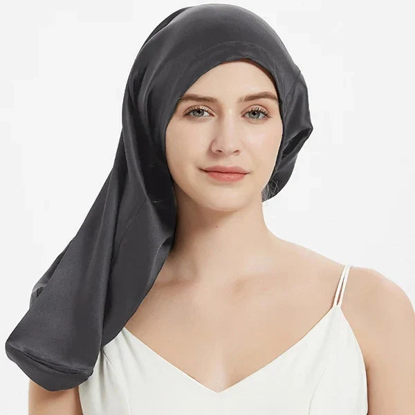Charcoal gray Mulberry Silk Sleep Bonnet for long hair, worn by woman. Adjustable silk headwrap for frizz-free hair and comfort.