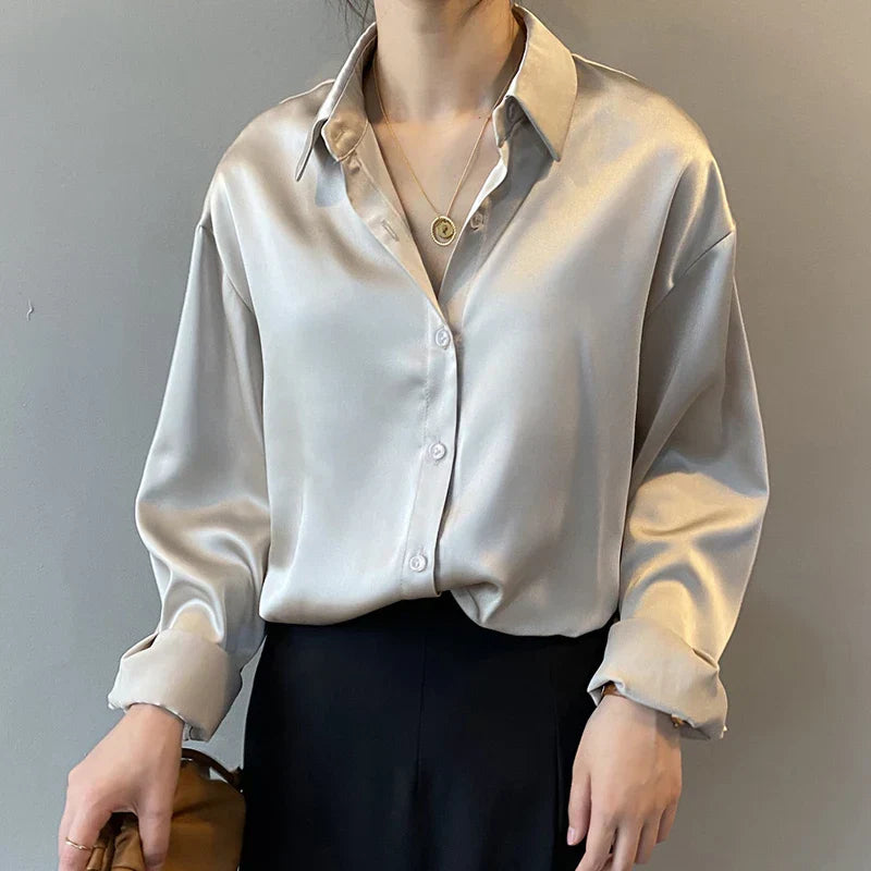 Navy blue satin blouse with long sleeves and a silky finish. A stylish and elegant choice for both formal and casual looks.