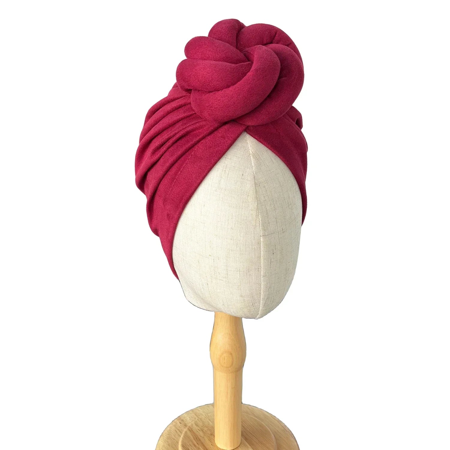 Dark pink soft knotted turban headwrap displayed on a mannequin, showcasing its elegant twisted knot design and smooth fabric.