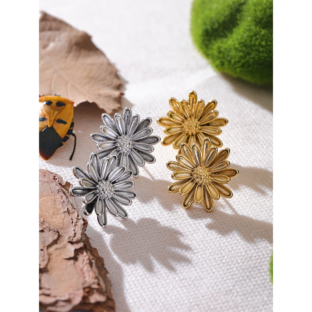 Two pairs of gold and silver stainless steel flower stud earrings on a natural backdrop. Stylish and elegant button stud earrings for women’s fashion.