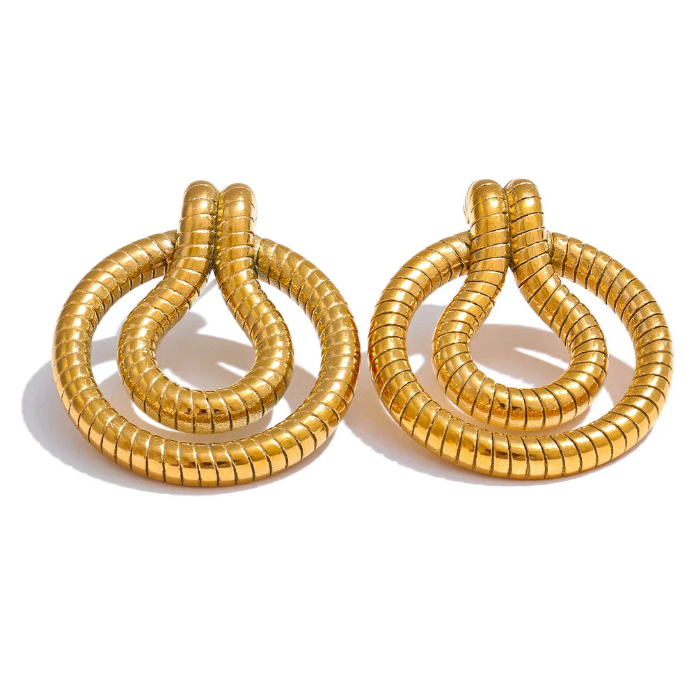 Close-up of stainless steel geometric snake earrings in gold-tone with a vintage African-inspired design. Elegant jewelry for women.