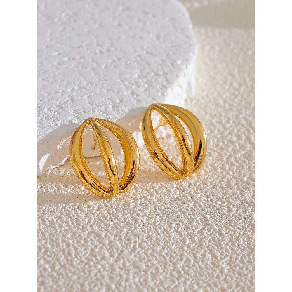 Gold stainless steel half-round geometric hollow stud earrings placed on a textured white surface. Elegant and timeless jewelry piece.