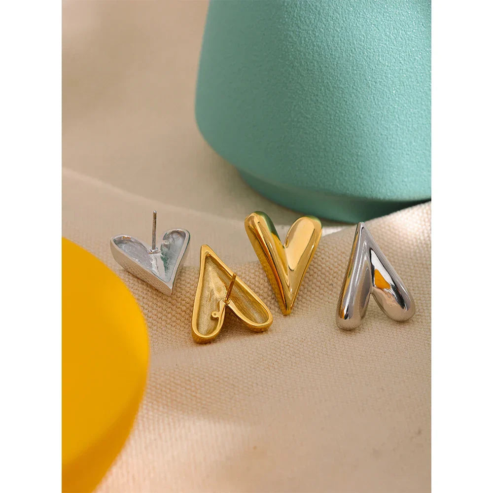 Gold and silver stainless steel heart stud earrings displayed together. A trendy and elegant jewelry option for women who love unique accessories.