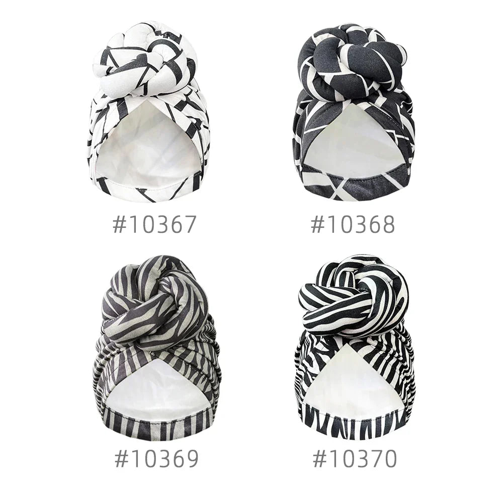 Four different patterned knot turban headwraps labeled with unique design numbers, showcasing stylish geometric prints in black and white.