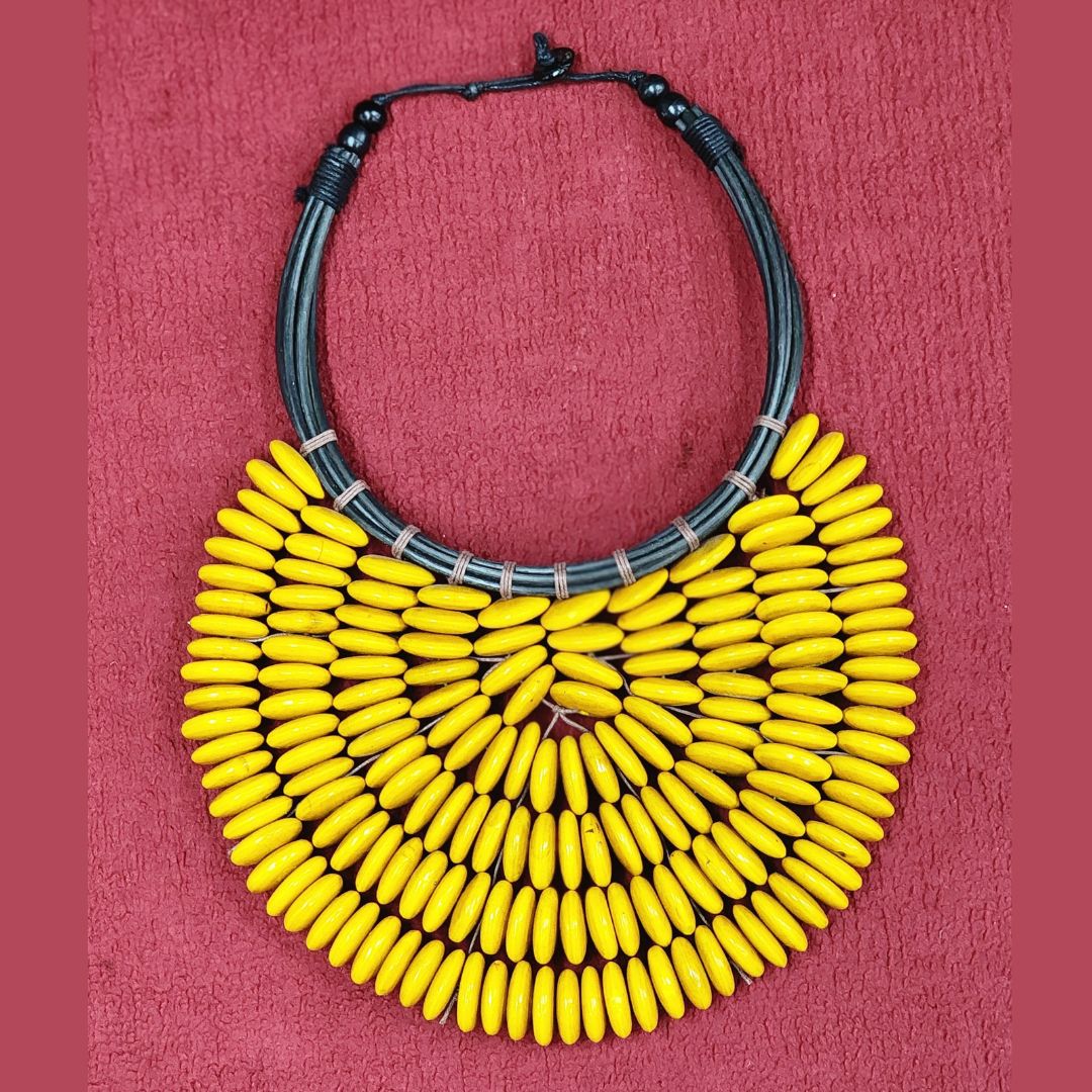 Handmade Citrine Cascade Collar displayed on a textured background, featuring yellow wooden beads and black cord. A bold and elegant handcrafted necklace.
