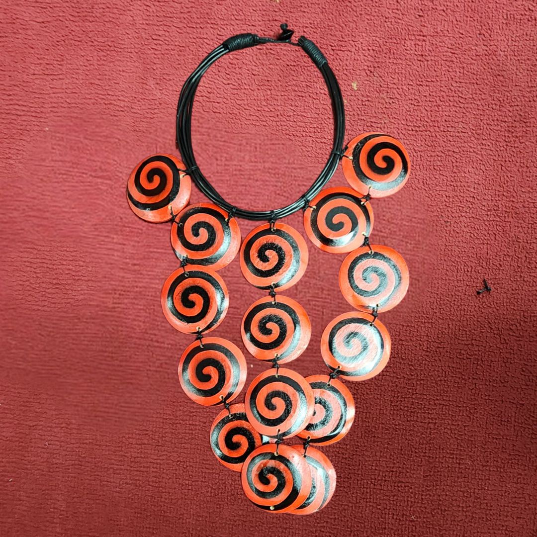 Tangerine Whirl Choker featuring bold orange and black spiral wooden beads. Handmade African necklace perfect for statement jewelry lovers.
