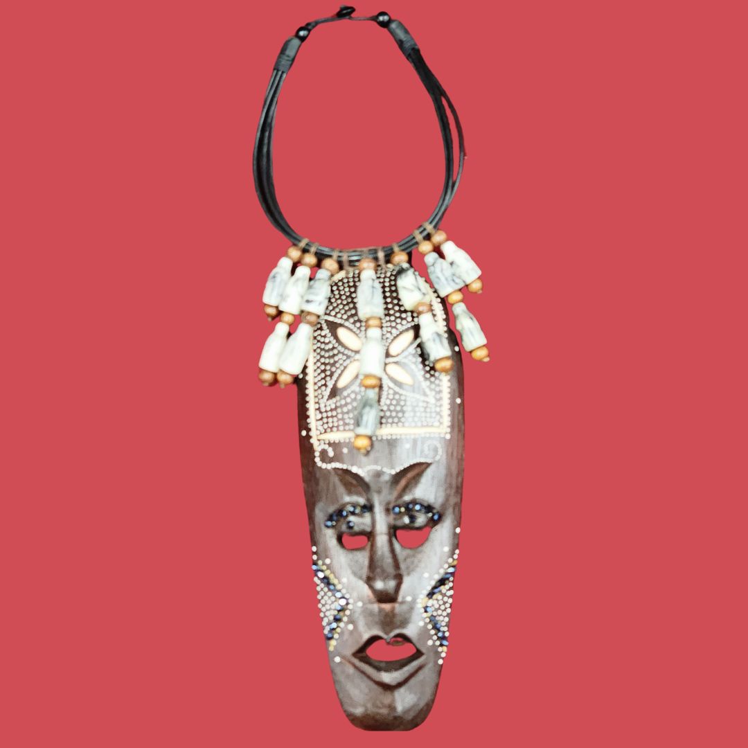 Tribal Bone Artifact Necklace featuring a handcrafted wooden pendant with intricate tribal face carvings, adorned with bone and wooden beads. A unique African-inspired statement piece.