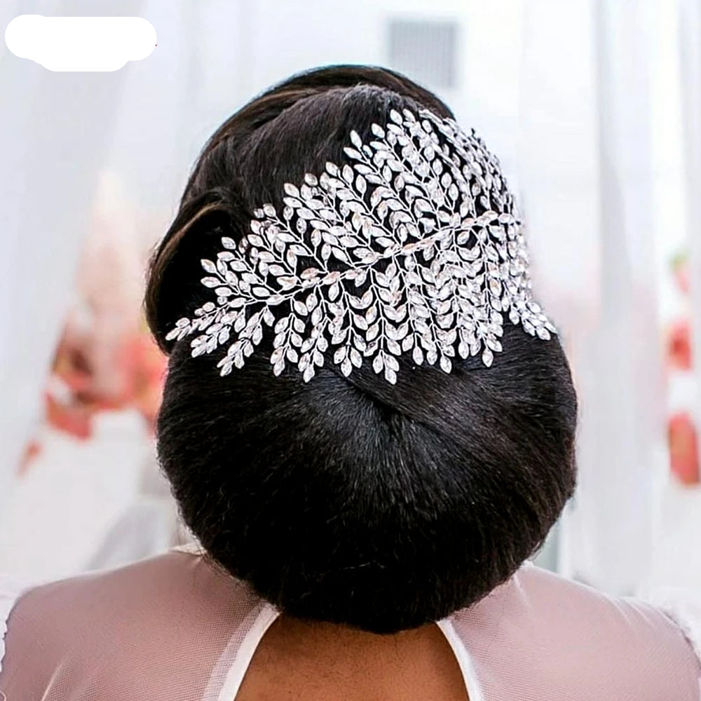 Bride wearing silver leaf tiara styled at the back over a low elegant bun hairstyle