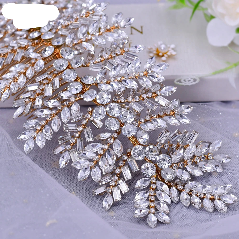 Gold leaf bridal hairpiece with sparkling clear crystals displayed on sheer fabric background