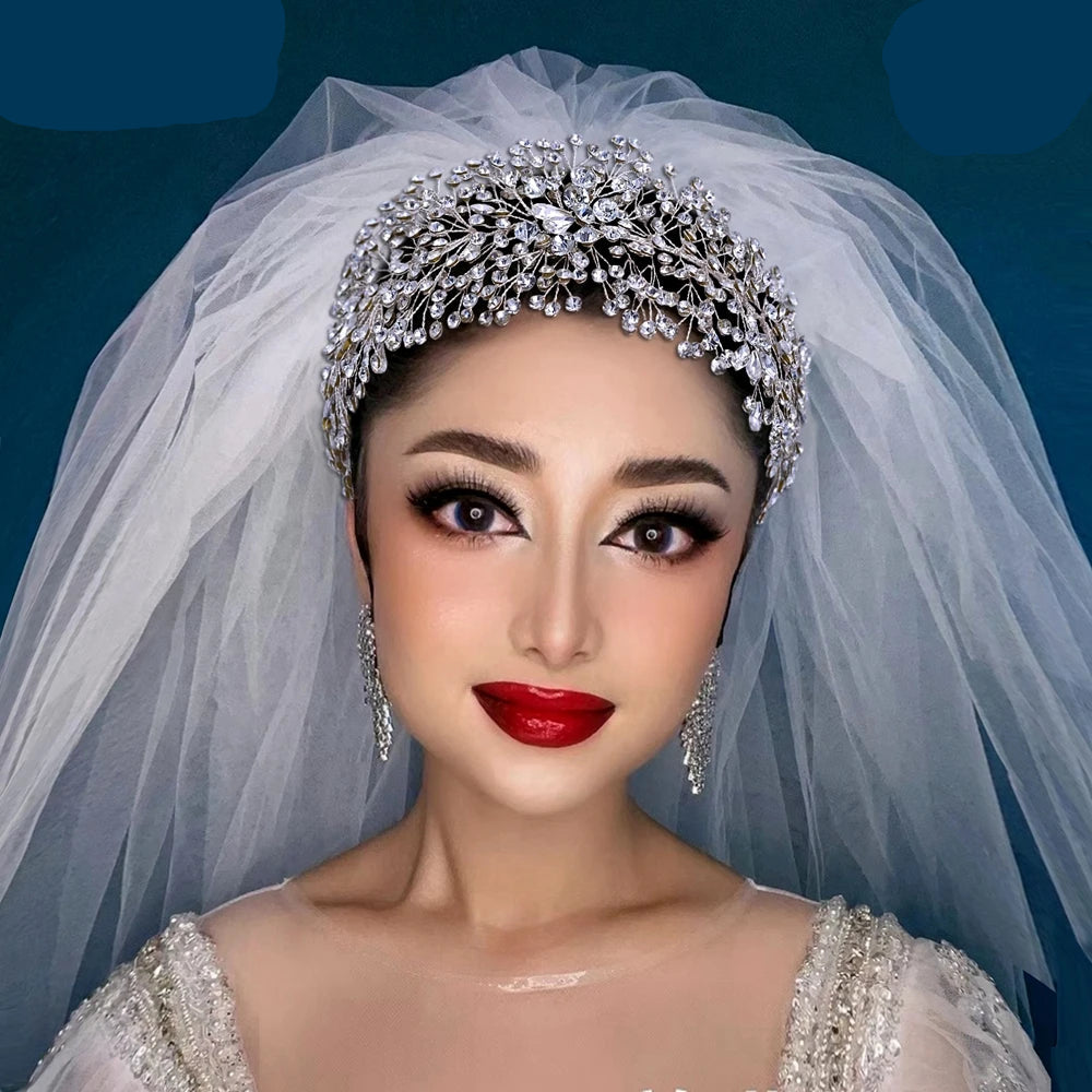 Bride wearing sparkling silver crystal tiara with veil, elegant statement bridal look