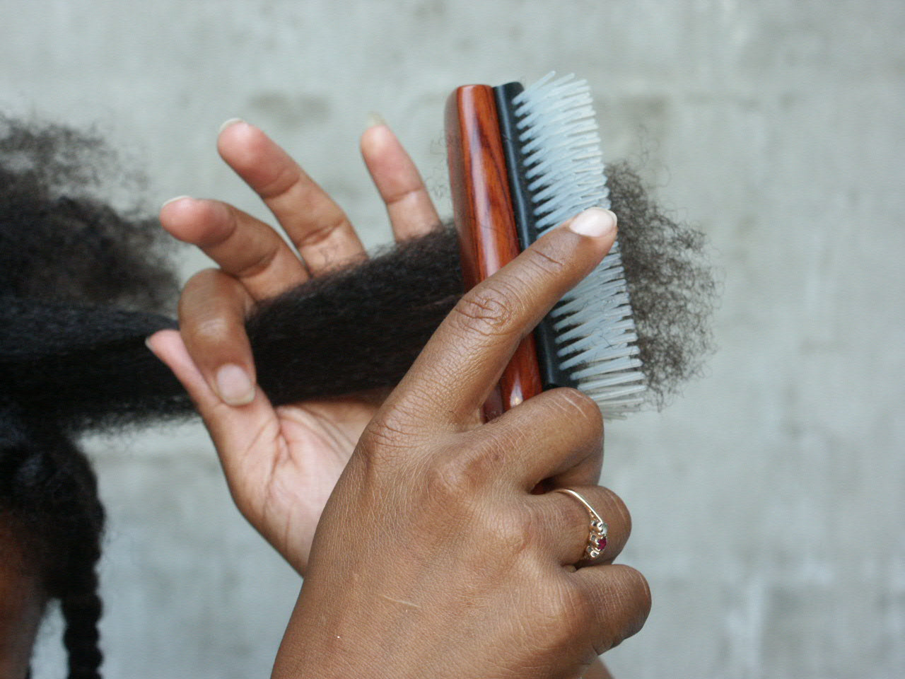 woman with type 4 hair combing her hair ou with the denman brush
