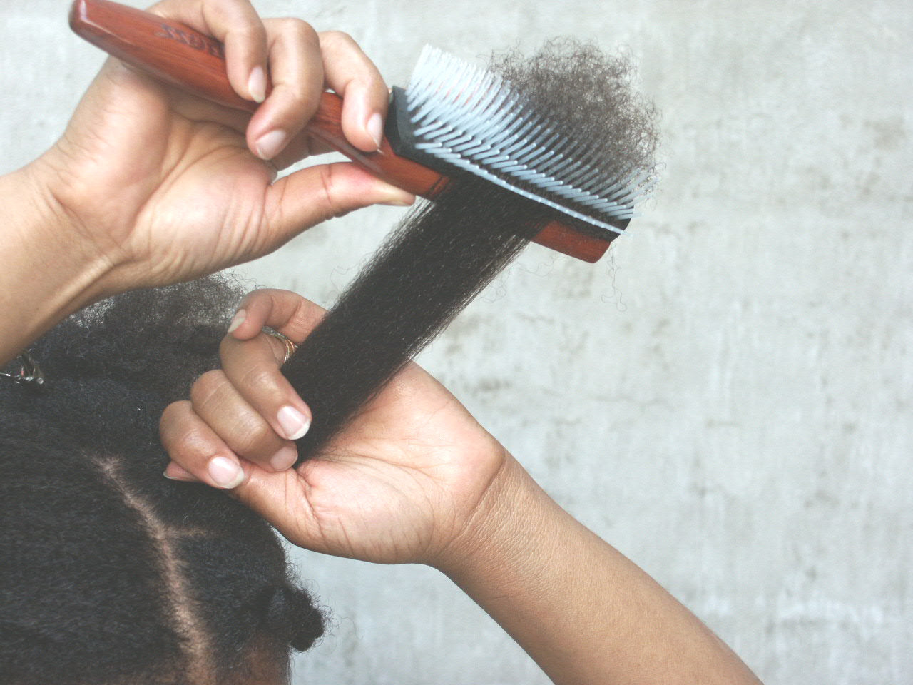 woman with type 4 hair using the denman brush to comb her hair out
