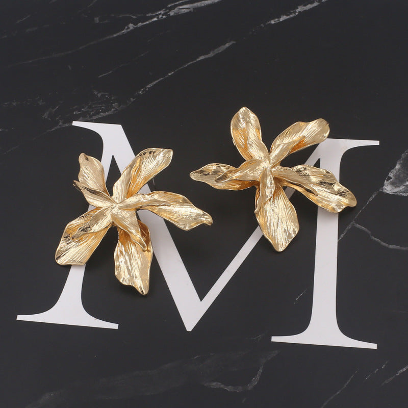 Kadija Luxe Bloom Earrings displayed on a black marble background, emphasizing their intricate floral design and luxurious gold finish.