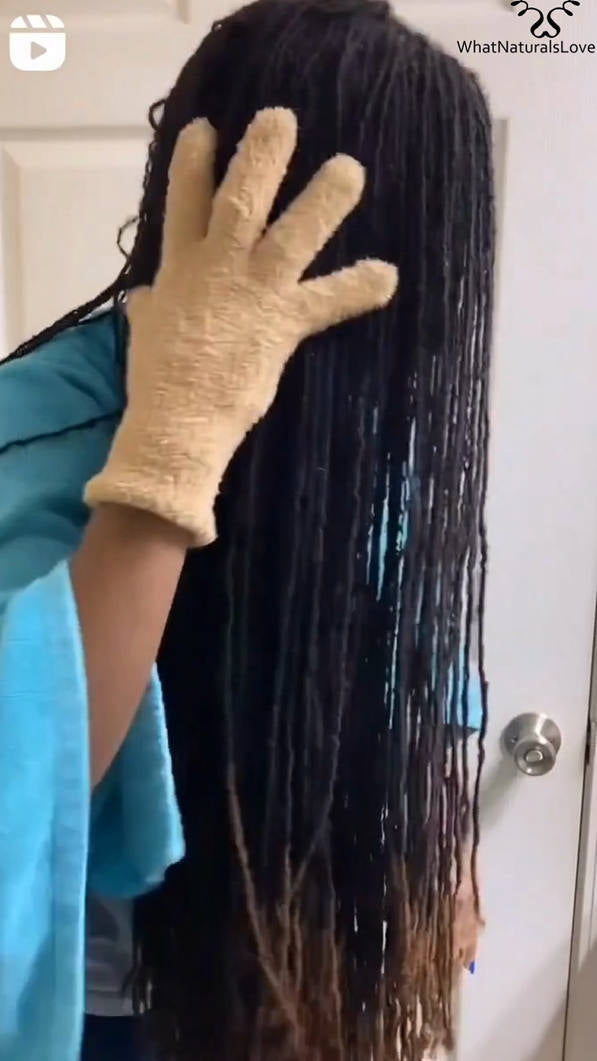 Person using an exfoliating glove on long, wet locs, part of the What Naturals Love Loc Care Bundle for scalp and hair treatment.