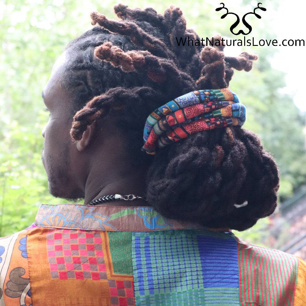 Adjustable moldable hair tie securing thick dreadlocks in a stylish updo. Designed for locs, braids, and Sisterlocks with a comfortable fit.