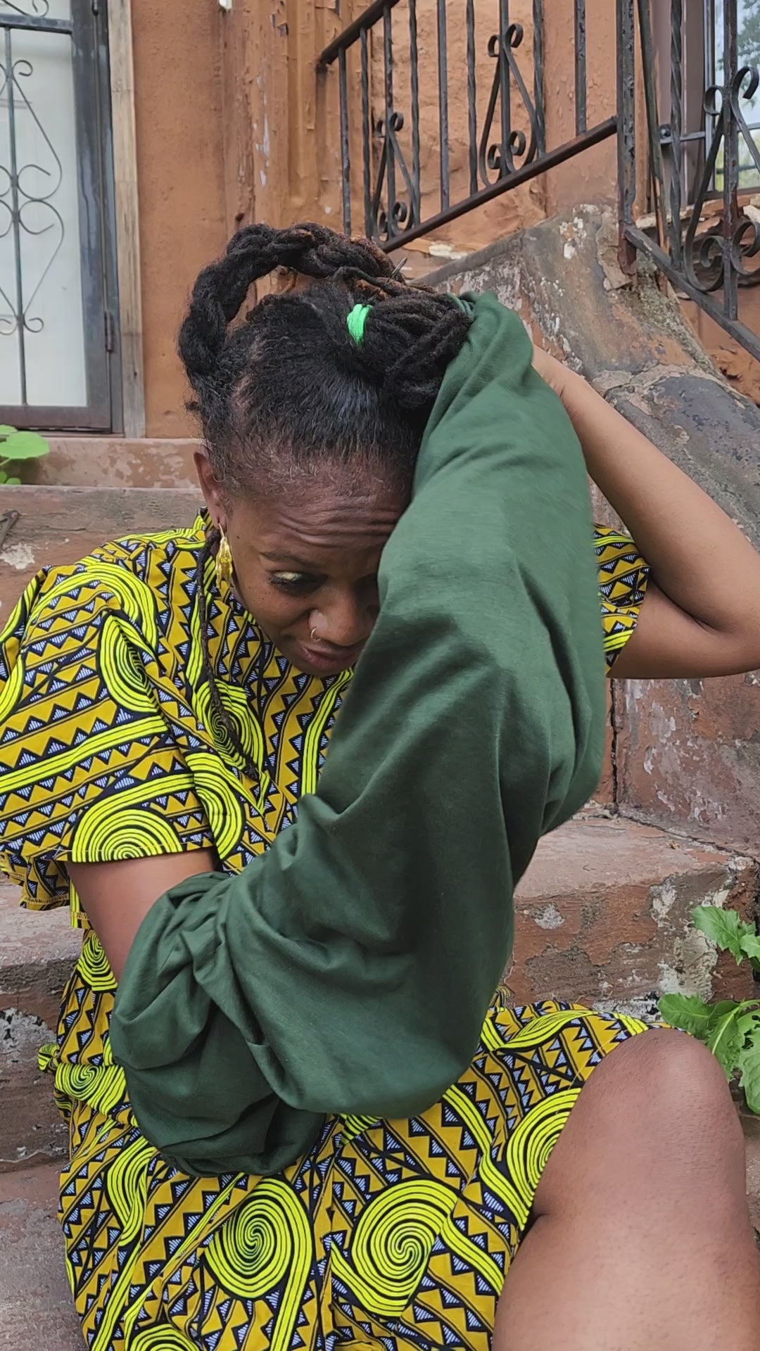 Woman styling a green tube headwrap for locs, sisterlocks, and dreadlocks. A versatile and protective hair accessory for natural hair.