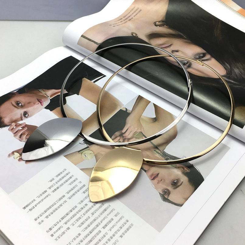 Gold and silver Outstanding Oval choker necklaces displayed on a fashion magazine. A chic and modern jewelry choice for Memorial Day 2024.