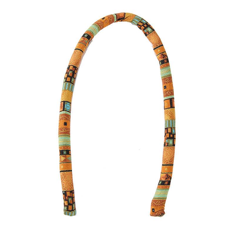 Extended view of an orange moldable hair tie. Flexible and stylish, ideal for locs, braids, and afro puffs.