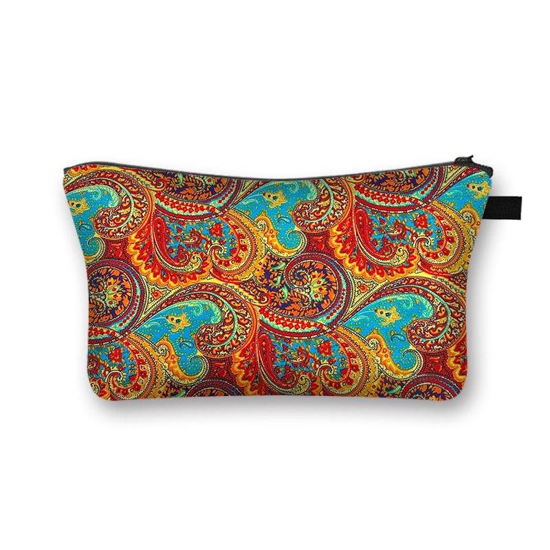 Paisley-patterned African print makeup bag with red, blue, and gold swirls. Elegant and spacious cosmetic pouch with lining.