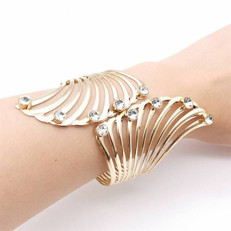 Gold cuff bracelet with fan-shaped crystal embellishments, offering a glamorous and luxurious touch to women&