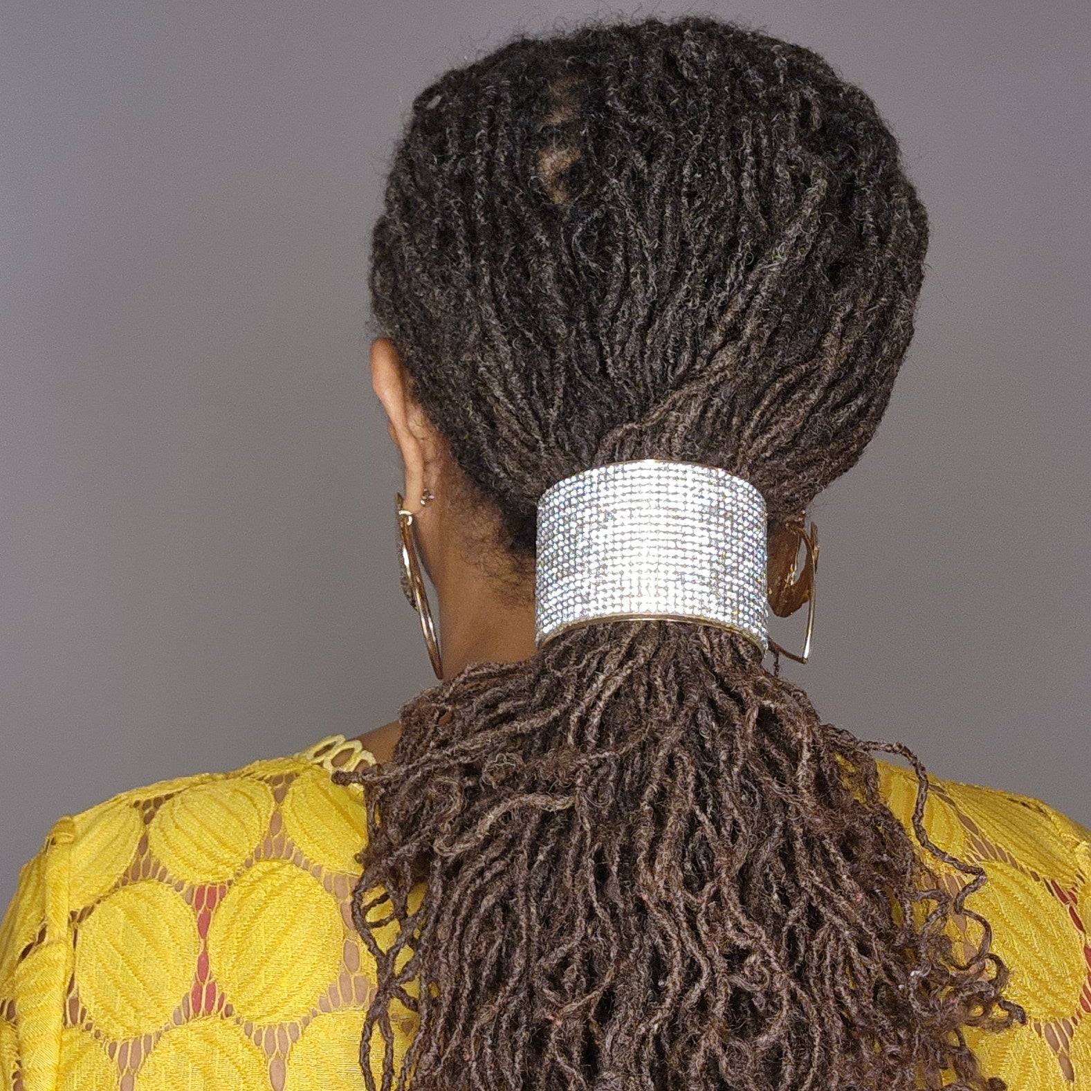 Woman with locs styled in a ponytail using a crystal-embellished hair cuff. A chic and secure hair accessory for braids and twists.