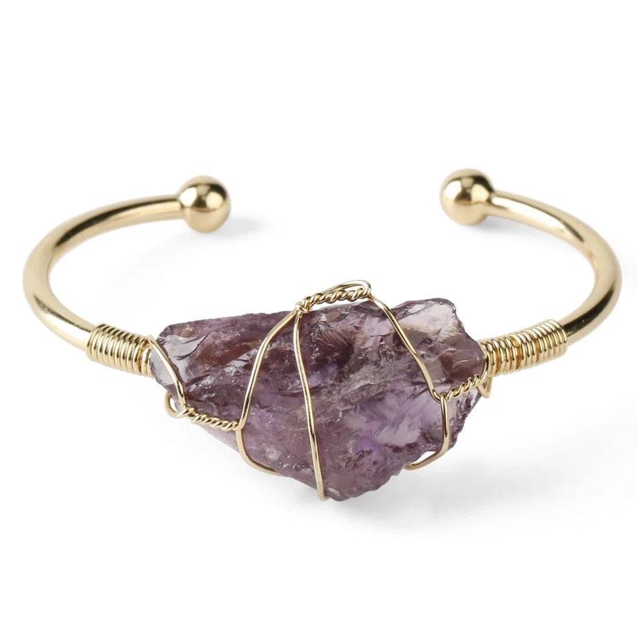 Gold-tone copper bracelet with wire-wrapped irregular purple crystal quartz centerpiece.