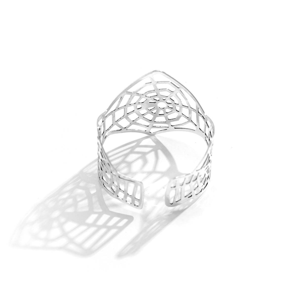 Silver spiderweb-inspired cuff bracelet with an open design. A unique and stylish accessory for a bold fashion statement.