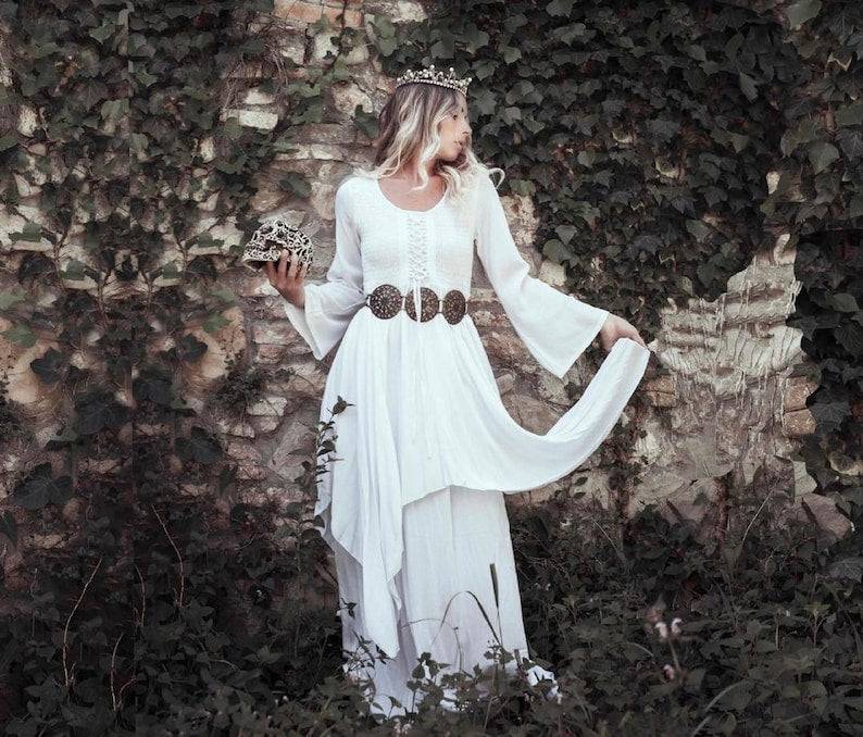 Elegant white Renaissance maxi dress with flowing layers and bell sleeves, accessorized with a crown and belt, perfect for fantasy or cottagecore fashion.