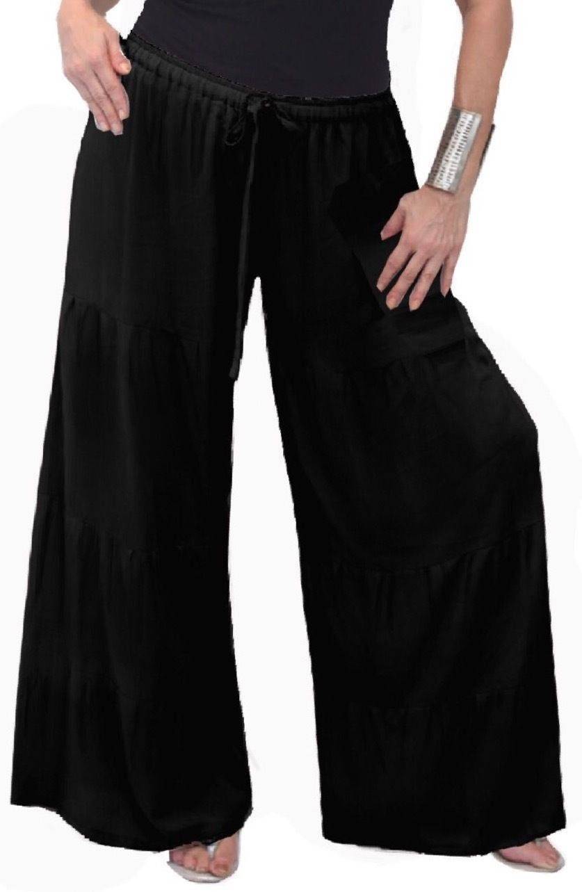 Black wide-leg pants with ruffled tiers and an elastic waist. Comfortable and stylish for casual or bohemian outfits.