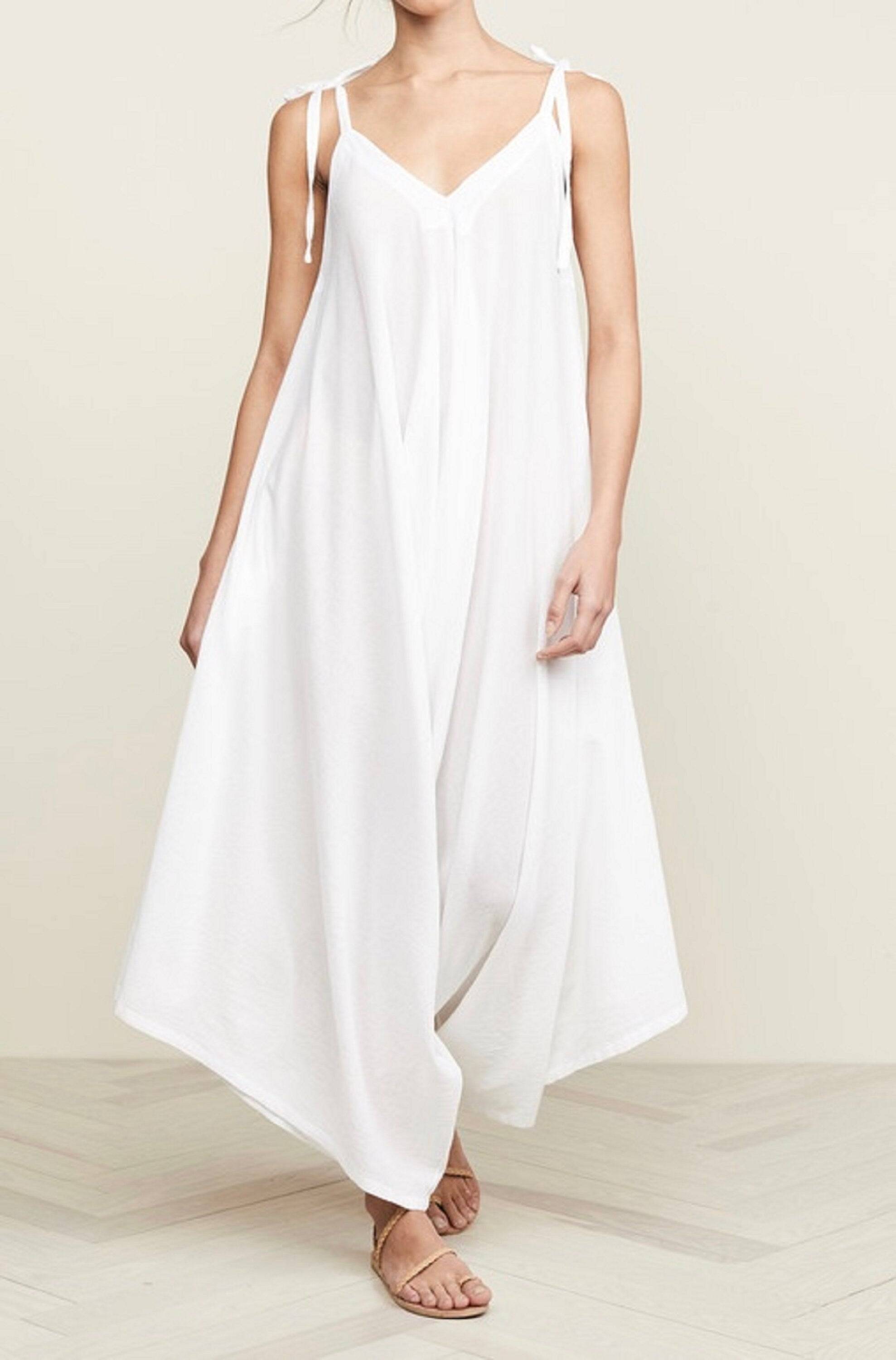 White spaghetti angled straps jumpsuit with loose leg, featuring a breezy and elegant design for summer wear.