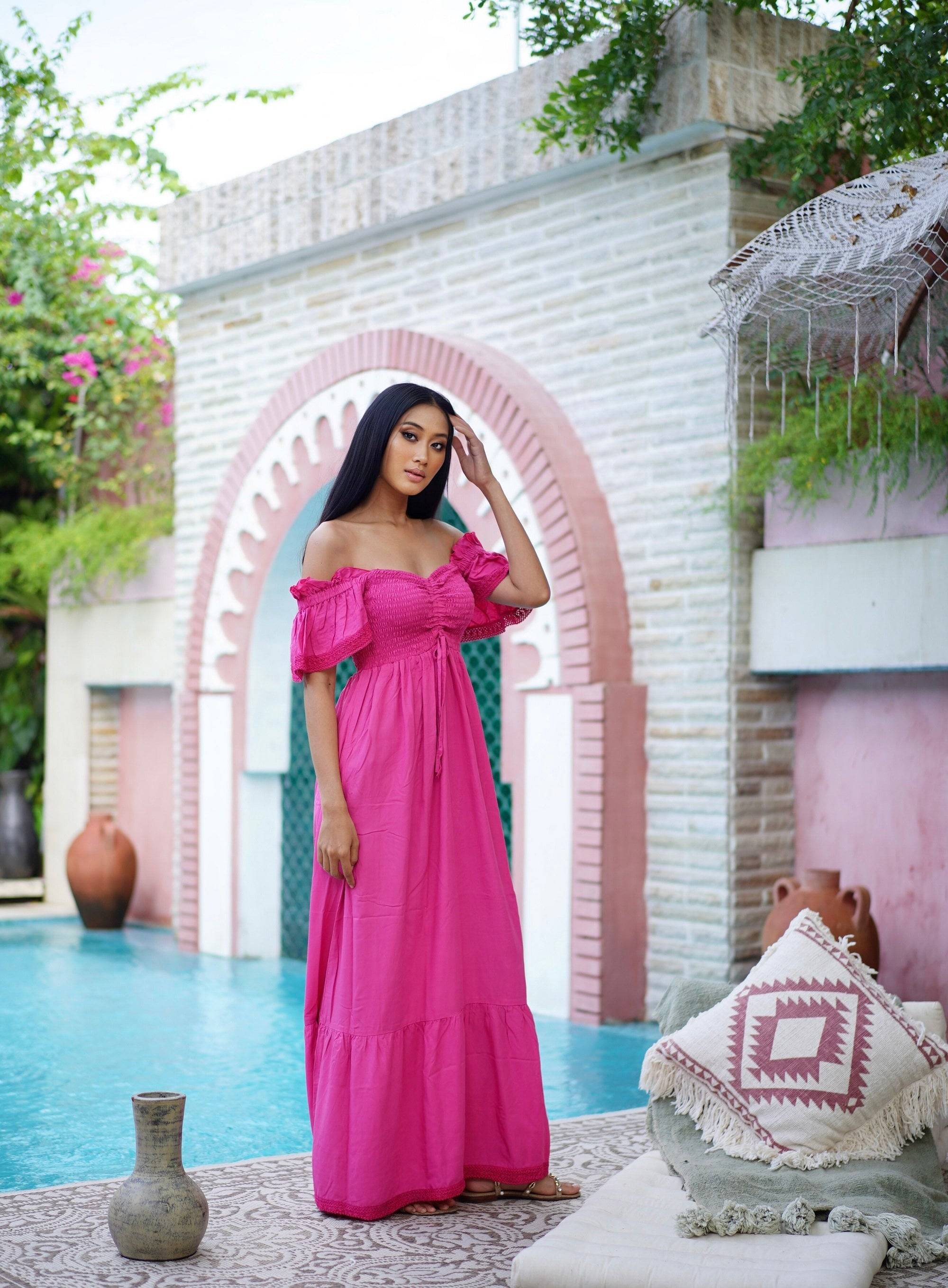 Vibrant pink maxi dress with smocked bust and ruffle lace trim, designed for a feminine and boho-inspired summer outfit.