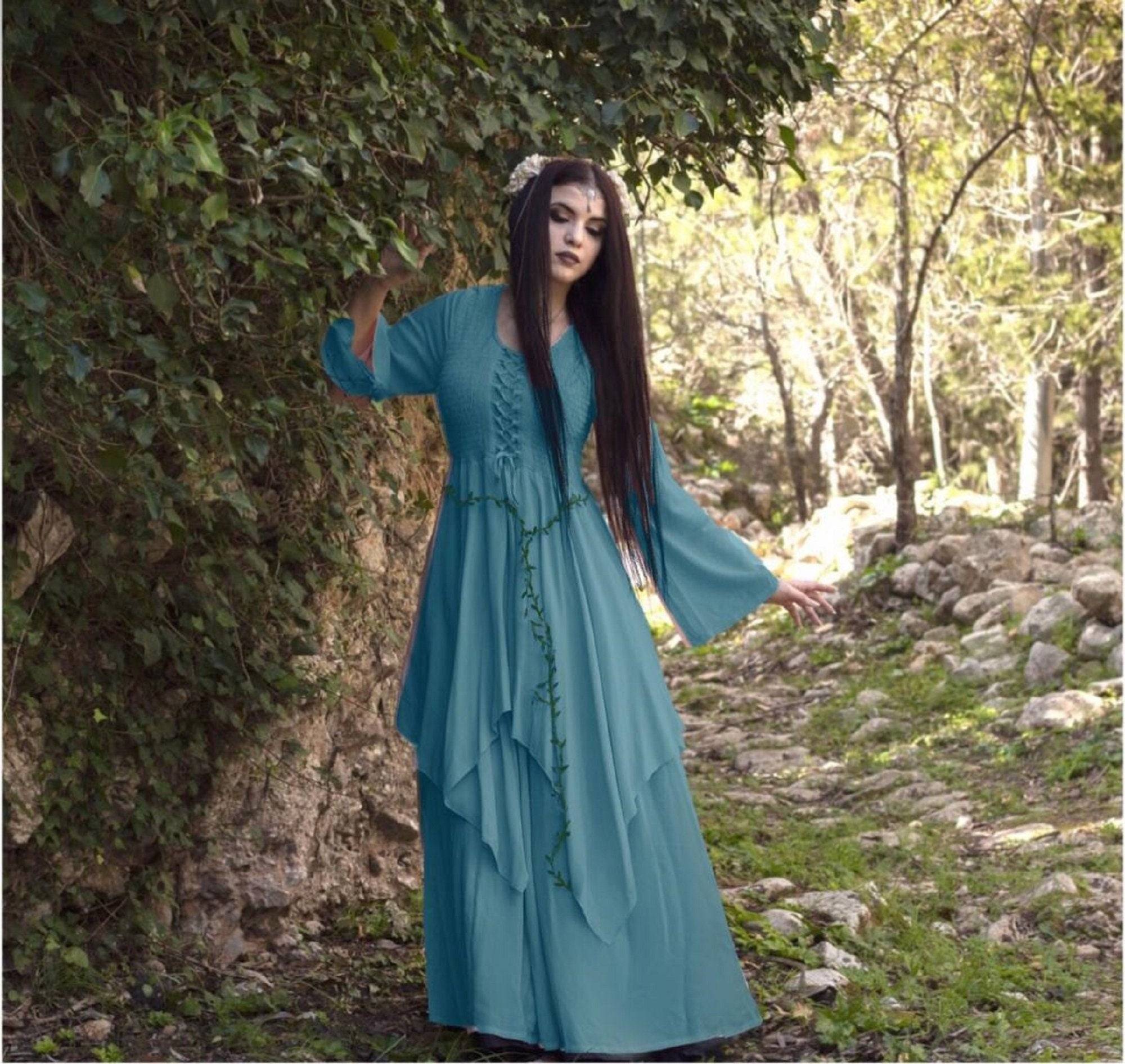Teal Renaissance maxi dress with lace-up front and layered skirt, worn in a mystical forest setting, ideal for fantasy or cottagecore aesthetics.