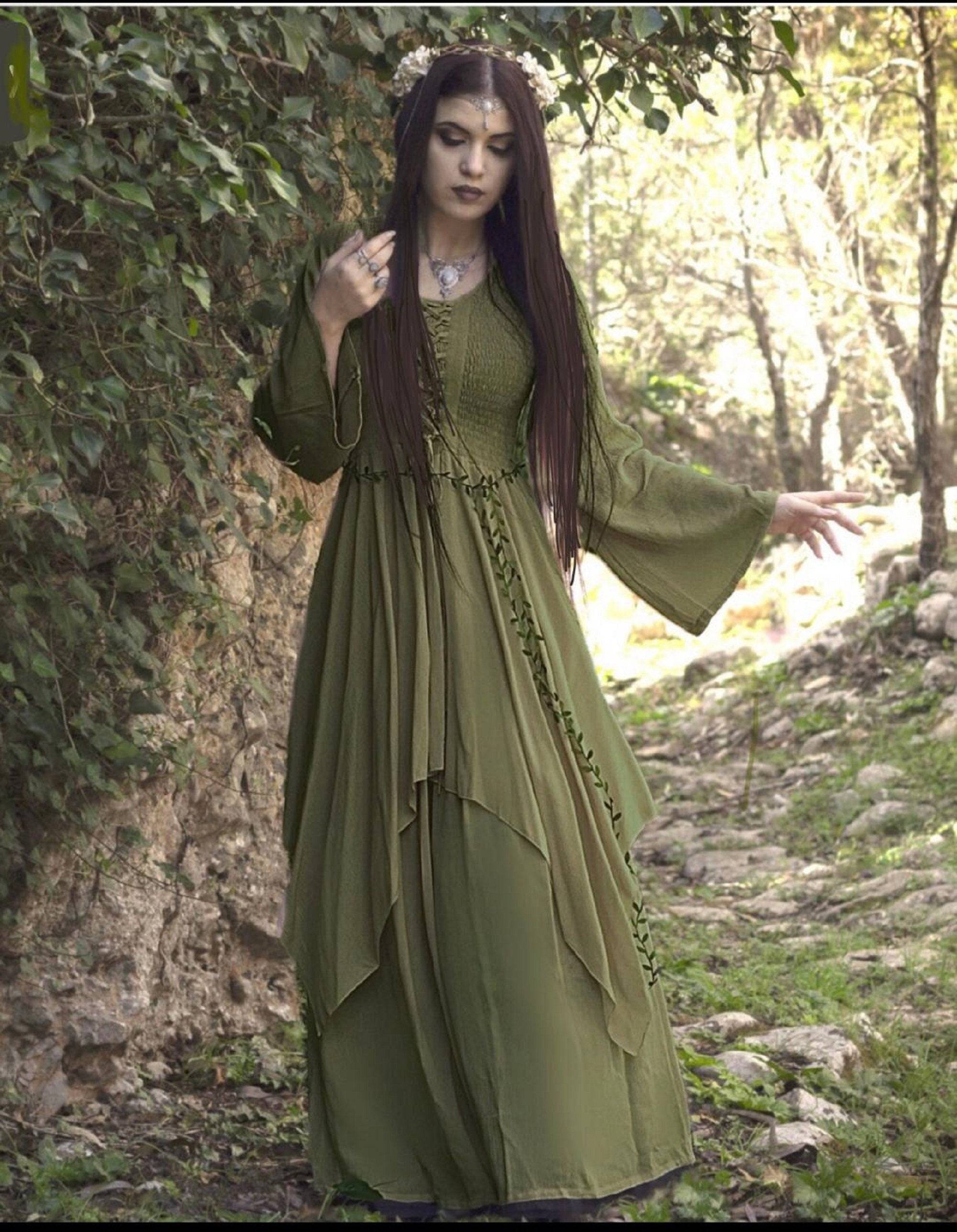 Olive green Renaissance maxi dress with lace-up bodice and layered skirt, styled in a woodland setting for a medieval or fantasy-inspired look.