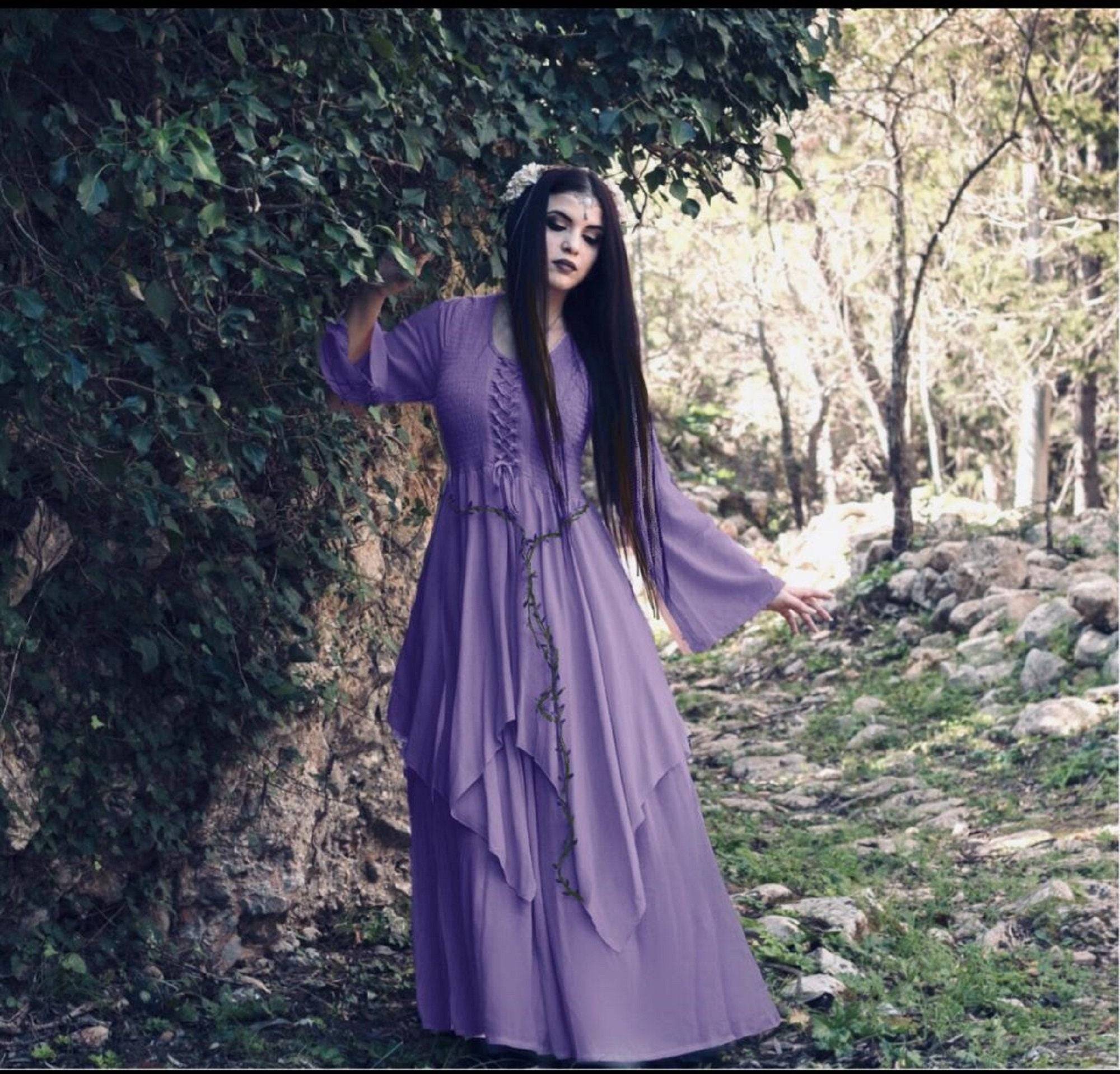 Lavender Renaissance maxi dress with lace-up details and flowing layers, worn in a mystical forest setting for a fantasy-inspired look.