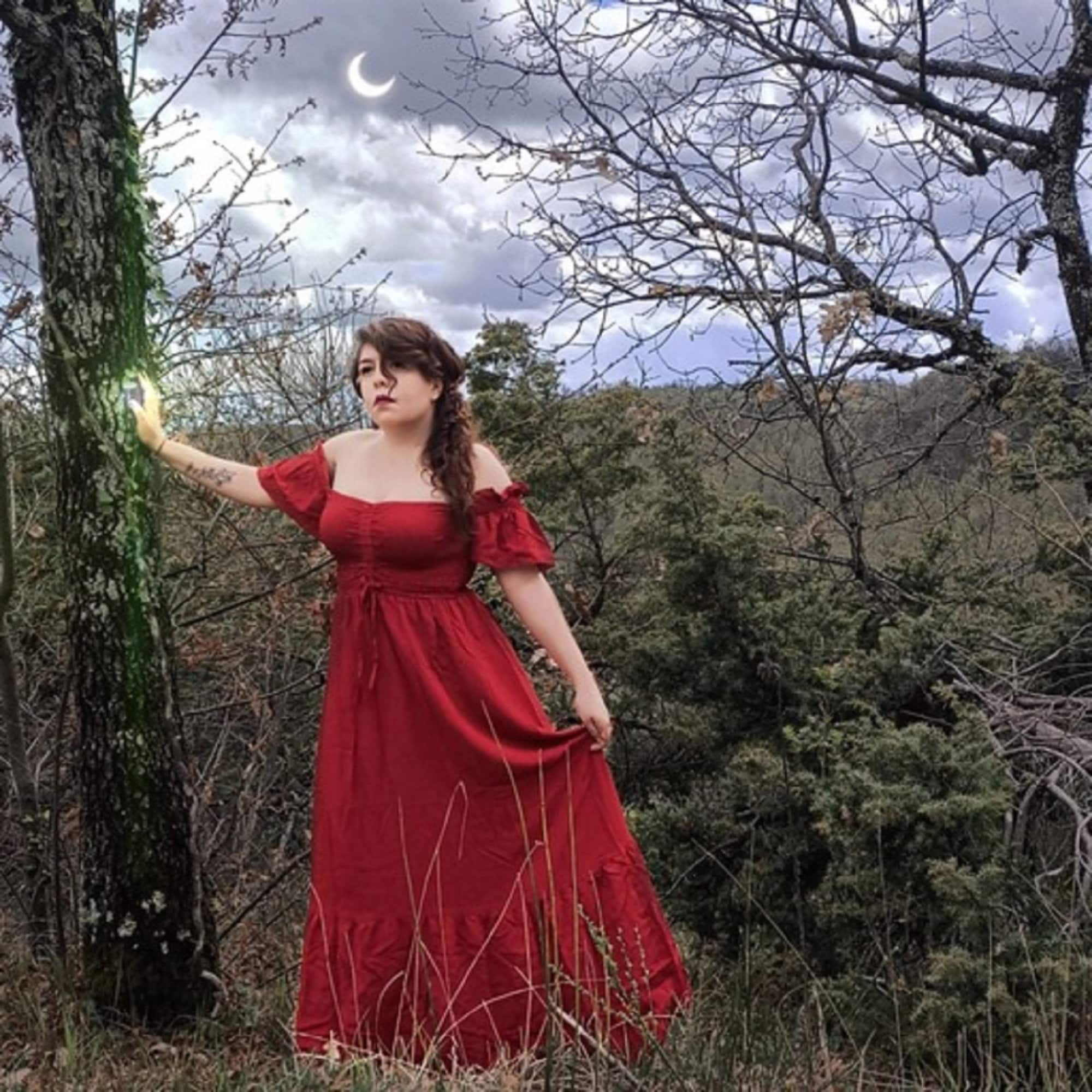 Enchanting red maxi dress with smocked bust and ruffle lace trim, styled in a magical forest scene with a glowing crescent moon.
